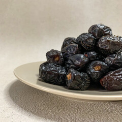 close up photo of a pile of Ajwa dates on a plate. ready to be served.