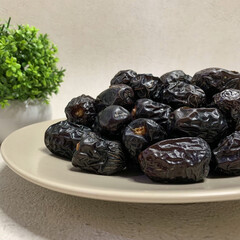 A bountiful plate of authentic Ajwa dates, known for their unique dark color and rich flavor.