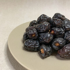 close up photo of a pile of Ajwa dates on a plate. ready to be served.