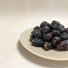 close up photo of a pile of Ajwa dates on a plate. ready to be served.