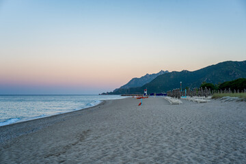 Obraz premium Foddini beach at sunset showing beach umbrellas and deckchairs in Sardinia, Italy