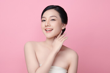 A beautiful young Asian woman with clean, fresh skin against a pink background. Skincare, facial...