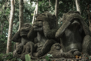 Monkey sculpture fully covered with green moss in Ubud's Monkey Forest. Bali, Indonesia.