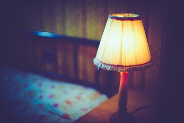 Warm lamplight illuminates a bedroom