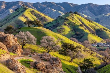 Naklejka premium Rolling hills, sunlit slopes, and distant mountains