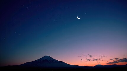 Majestic mountain silhouette against a twilight sky dotted with stars and a crescent moon.