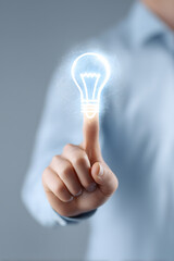 Hand Touching Glowing Light Bulb Icon Representing Idea