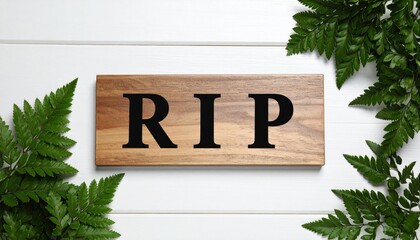 Wooden sign with RIP text surrounded by ferns