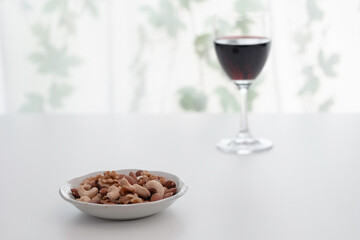 ミックスナッツとグラスに注いだ赤ワイン