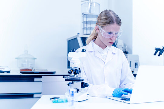 Closeup female scientist working data on laptop in the laboratory. Technology for research, discussion and digital analysis
