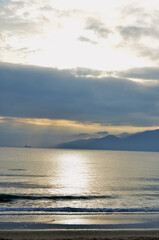 Obraz premium Sunrise on the seacoast. Nature, landscape of sunrise on the seashore with calm sea and mountains in the distance.