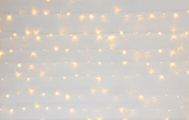 Soft warm white string lights on neutral background creating cozy atmosphere.