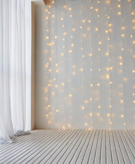 Cozy indoor setting with soft white curtains and warm string lights on white wooden floor.