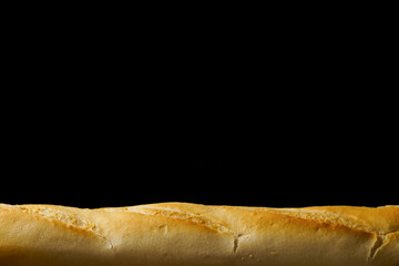 Close-up of golden crusty baguette on a dark backdrop, offering ample copy space for text or design