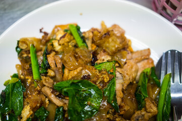 Pad see ew is a popular Thai street food featuring stir fried flat rice noodles pork and with dark soy sauce