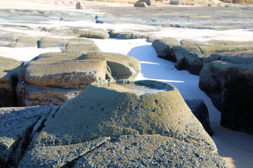 Strange raised rock pool on the wave cut platform at Soldiers Point New South Wales Australia. Eroded geological feature with a small pool in it.