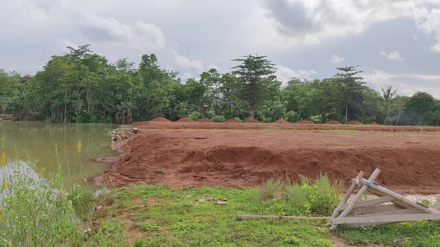 A wide area of open land cleared and leveled in preparation for a residential housing project. site shows early stages of property development, with flat soil marked sections ready for construction