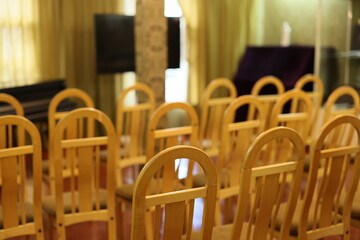 The area has neatly arranged empty chairs ready for an event in a simple, spacious hall