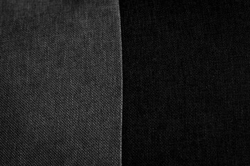 Description: Contrasting fabrics: textured dark grey and smooth black meet. Close-up highlighting...