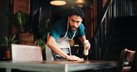 Cleaning, spray bottle and wipe with man in coffee shop for disinfection, hospitality or hygiene....