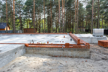 Concrete slab of foundation of house with laid pipes start of construction on project. Construction of cottages, design, engineering communications.