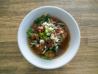 Dumplings or wontons or yamien dumplings are served with a mixture of bean sprouts, spring onions, fried onions, vegetables, and a special yamien sauce.