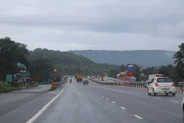 Rainy Day Driving on a Coastal Highway Surrounded by Lush Greenery and Palm Trees