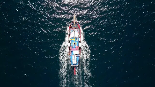 Aerial drone footage of a sailing ship sailing the sea and circling the island of Thassos