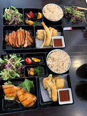 Japanese lunch box bliss! Grilled salmon, teriyaki chicken, crispy tempura, fresh salads, and fruit - Japanese lunch done right.