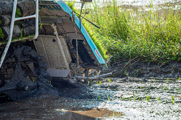 Professional local Asian farmer and agriculture vehicle machine transplant rice seediing in a paddy field in the open sky day.