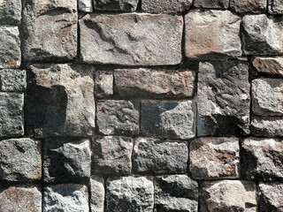 Close up of 3D dark stone bricks with weathered and rough surfaces. Outdoor natural paving stone tiles, suitable for floor and wall finishes. Seamless background texture.
