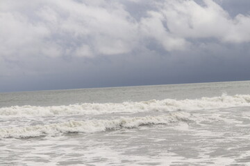 Crashing Waves Under a Cloudy Sky Creating Beautiful Ocean Foam Patterns