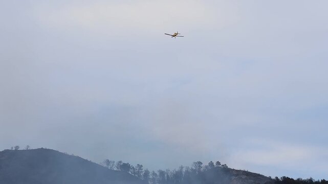 Hidroavi&oacute;n no reconocible se adentra entre el humo hac&iacute;a el incendio forestal en el parque natural Font Roja en julio de 2025, Ibi, Alicante