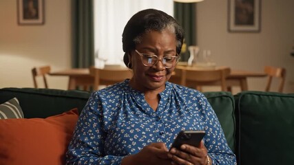 Elderly black African American woman typing on a smartphone, dolly push in - Powered by Adobe