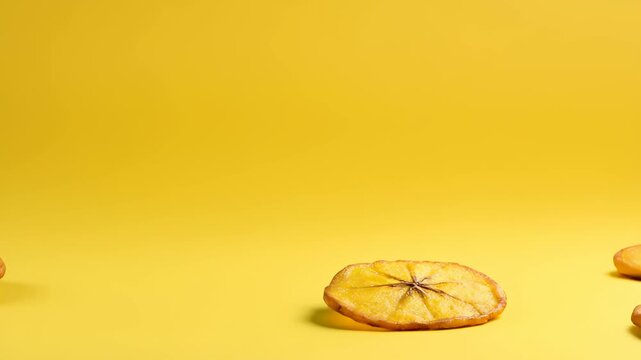 Stack of Golden Fried Plantain Chips on Yellow Seamless Background Featuring Crispy Textures