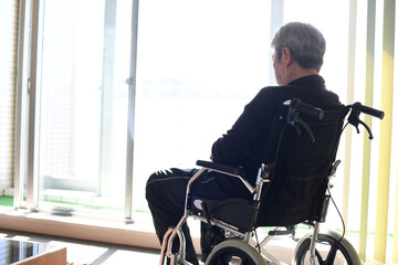 車椅子に座るアジア人の高齢男性の後ろ姿