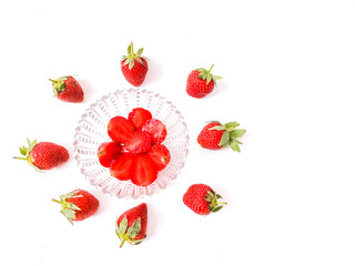 Fresh red strawberries isolated on a white background. And half berries served on transparent plate.