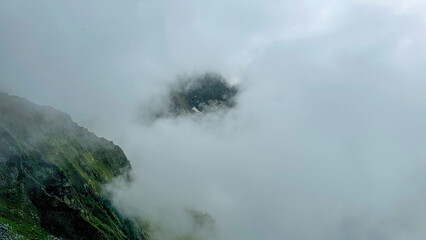 Fototapeta premium Foggy Mountains with Hidden Green Cliffs