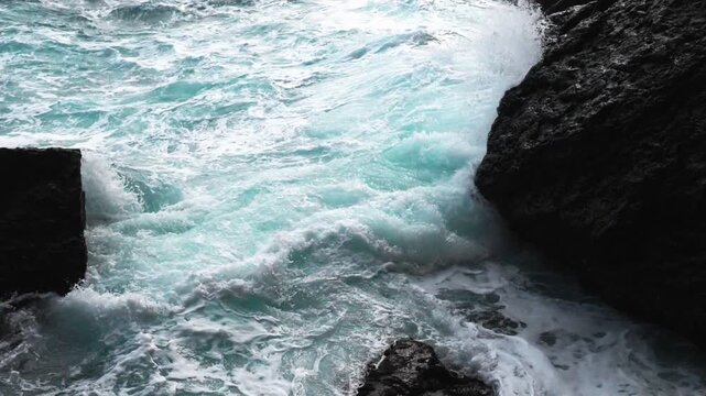 Green energy. Renewable energy sources. Perpetual motion machine. Pure bright turquoise waves break into white foam on the coastal cliffs and seethe between them. The need to protect the environment