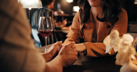 Holding hands, date and love with couple in restaurant for romantic anniversary, bonding and fine...