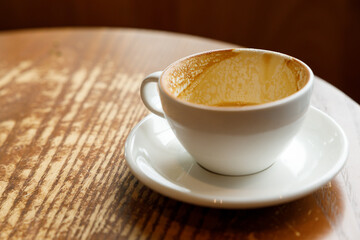 Empty cup of hot milk latte coffee on table by the window.
