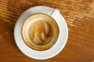 Empty cup of hot milk latte coffee on table by the window.