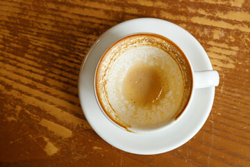 Empty cup of hot milk latte coffee on table by the window.