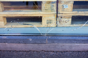 Close-up of cracks in shop window at town square Schwamendingerplatz on a late spring morning. Photo taken June 19th, 2025, Zurich Schwamendingen, Switzerland.