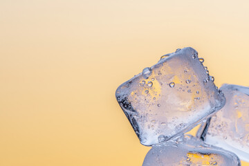 Melting ice cubes glisten with droplets against soft beige background, creating refreshing and serene atmosphere