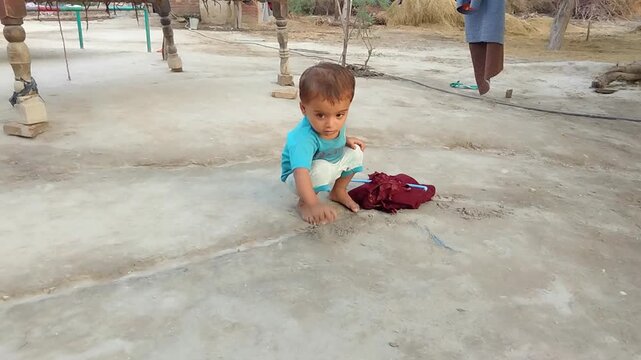baby girl playing with mud village child Rural toddler playing alone