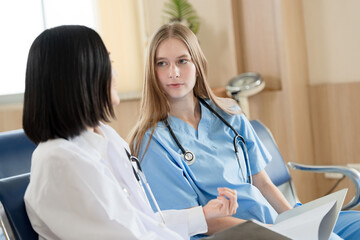 Caucasian doctor woman working and talking with major Asia woman medical student at hospital	