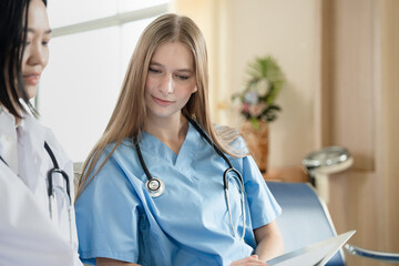 Caucasian doctor woman working and talking with major Asia woman medical student at hospital	