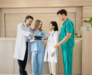 Caucasian woman doctor use tablet computer with team working at hospital	