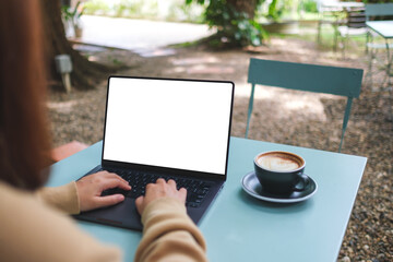 Mockup image of a woman working and typing on laptop computer with blank white desktop screen in the outdoors